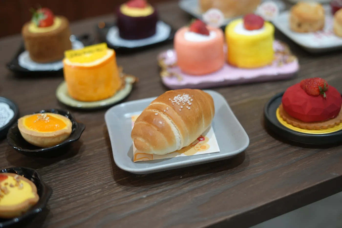 A croissant among the bakery's small tarts and cakes.