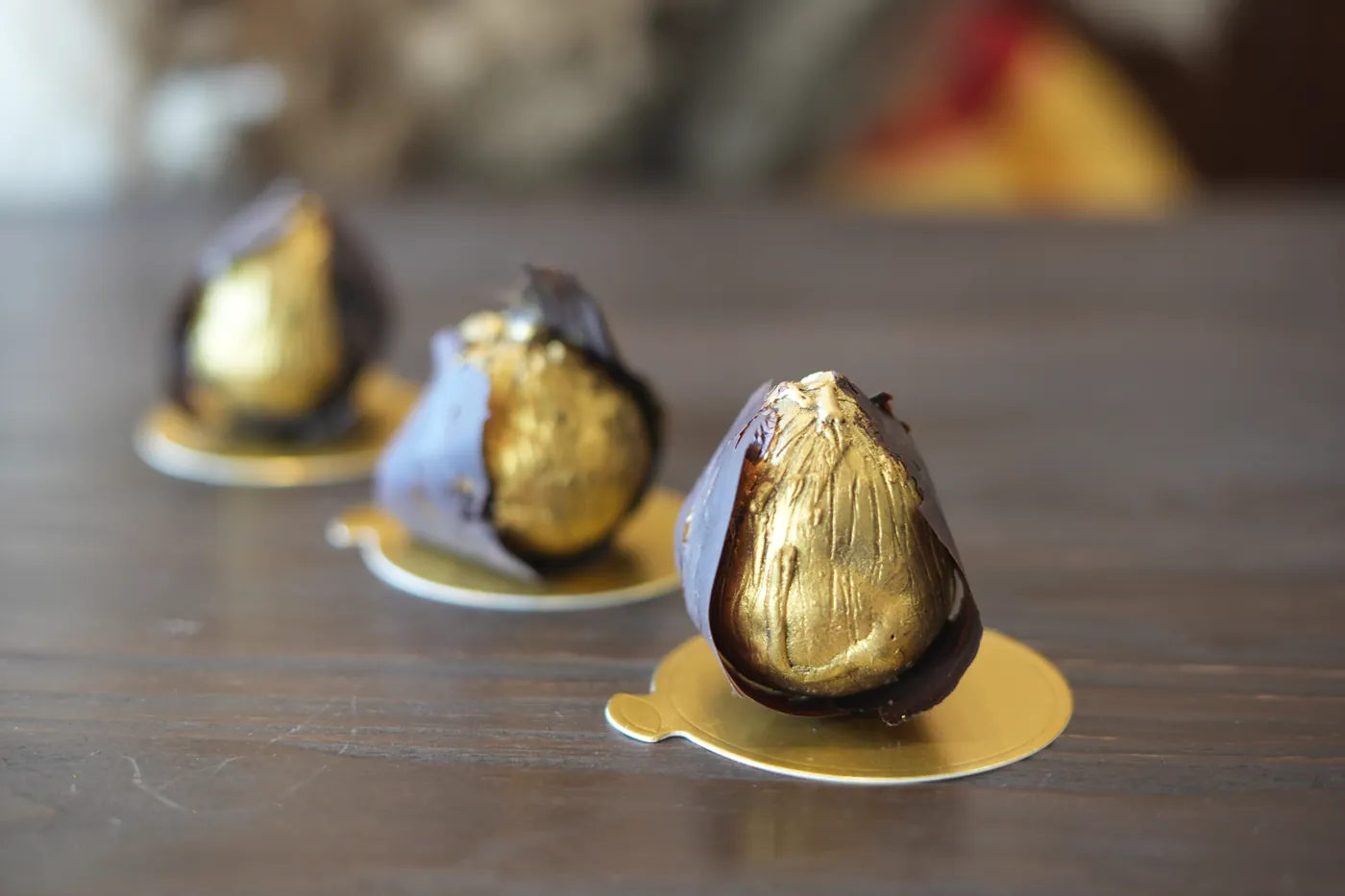 Chocolate pears with gold leaf on gold boards.