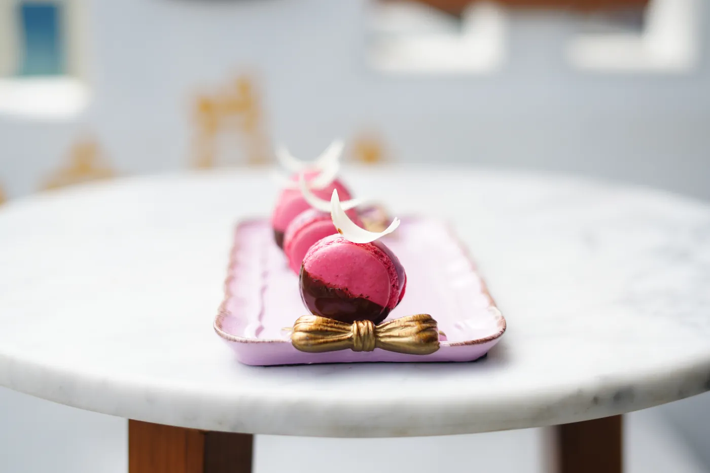 A pink entremet with a gold bow on a pink plate.