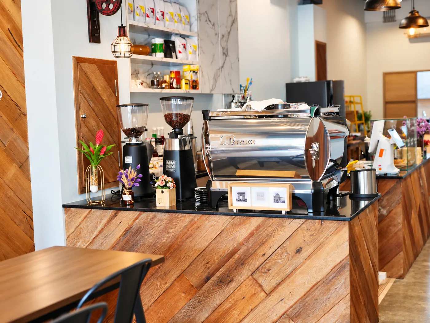The coffee bar counter in wood, with the espresso machine and the grinders.