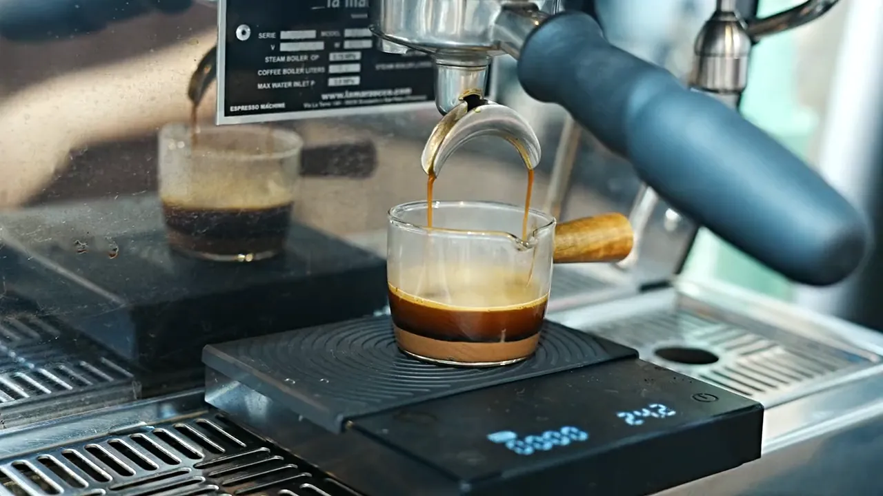 An espresso running into a glass on the scale at Ray's coffee bar.