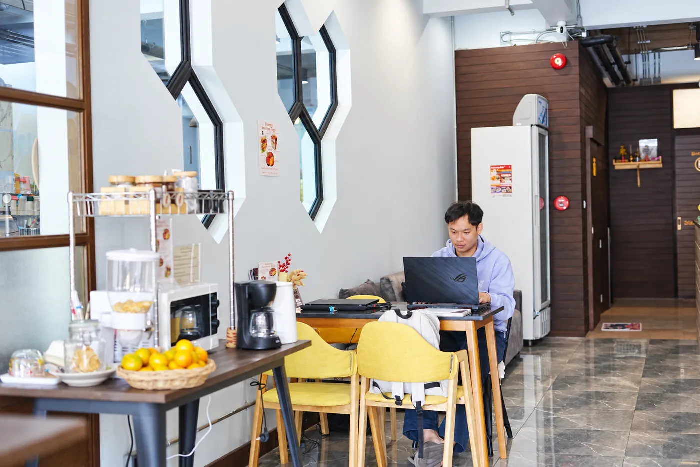 A guest working on his laptop at the yellow chairs in the common area.