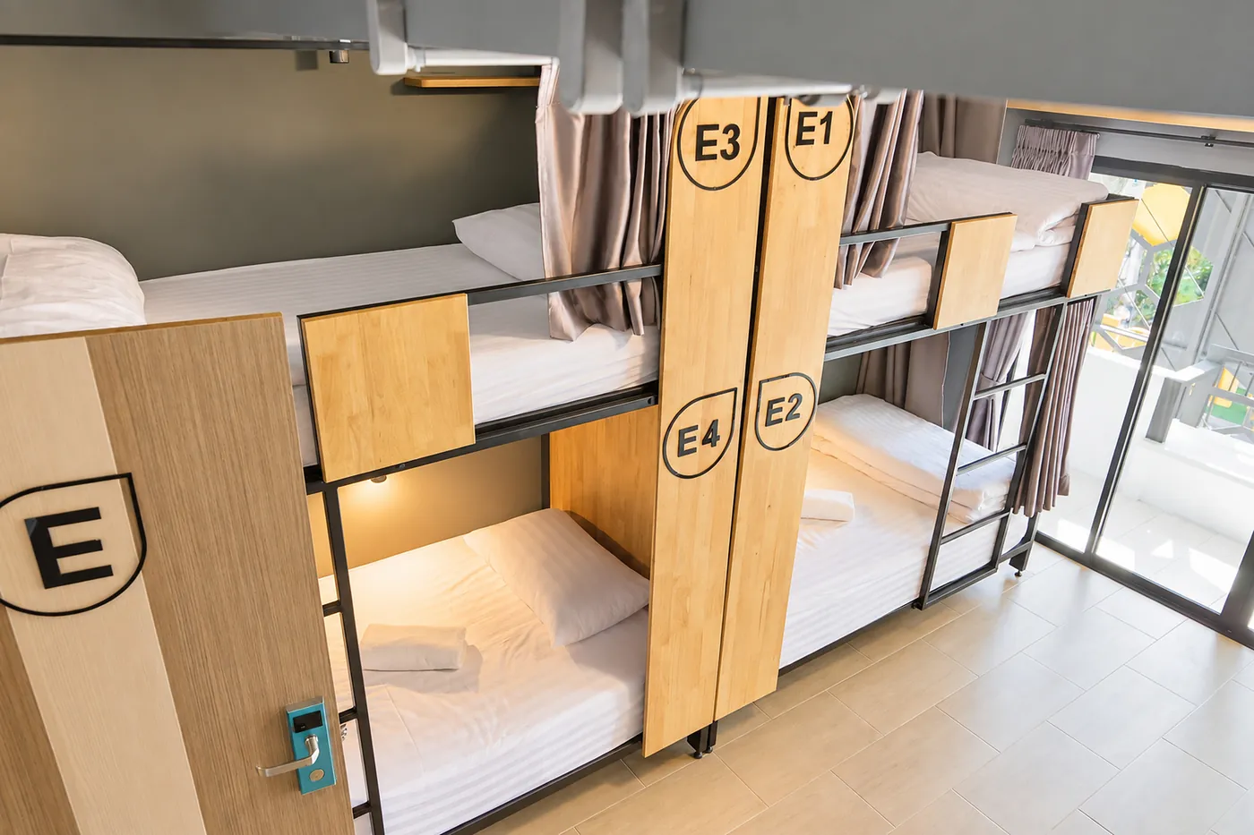 Bunks E1 to E4 with their curtains open and the balcony door beyond.