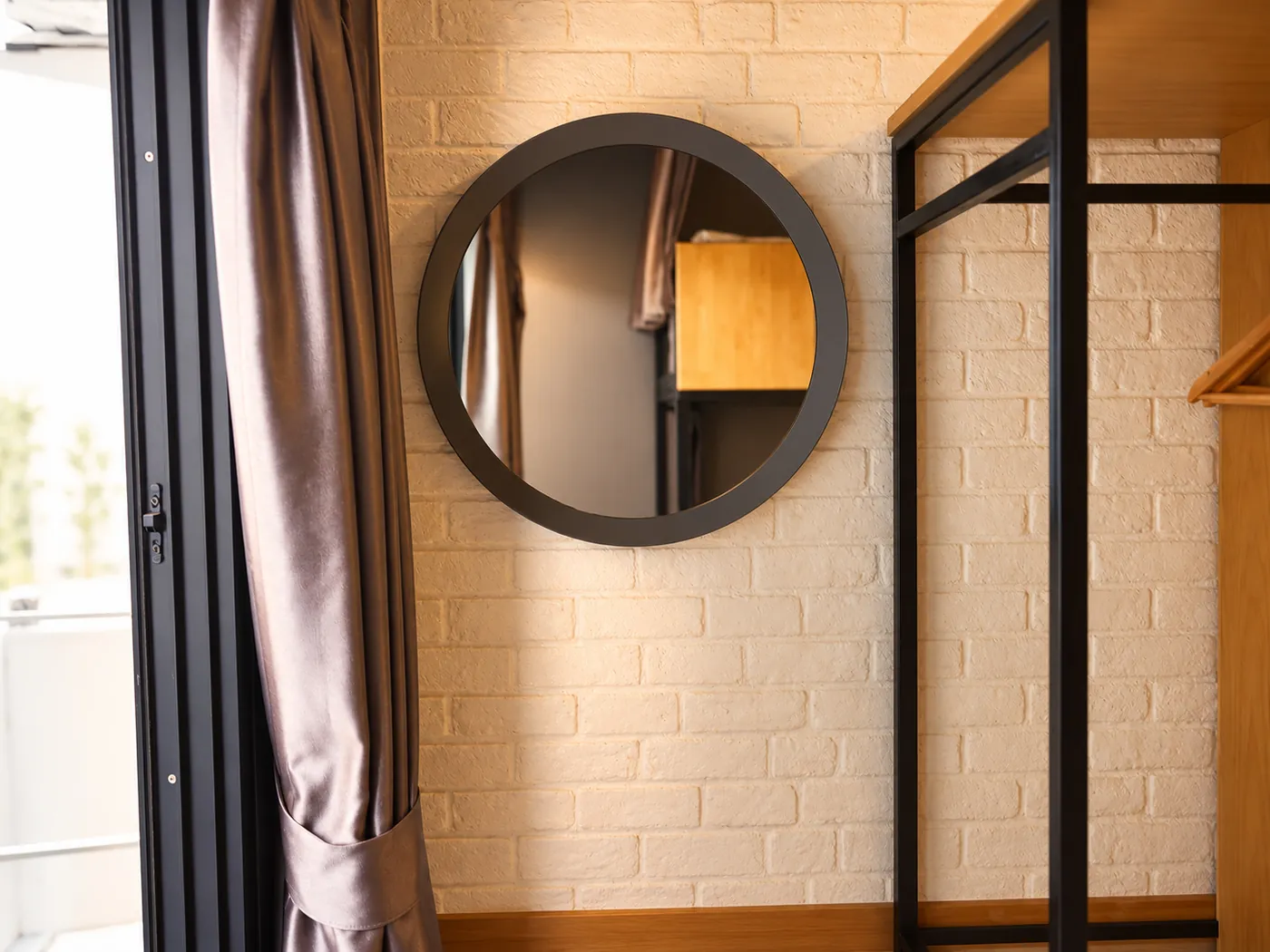 The round mirror and wardrobe beside the bunks.